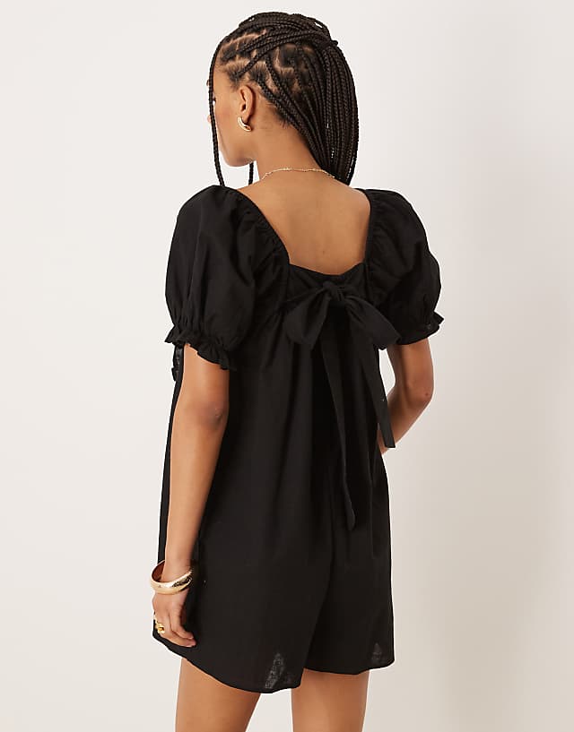Asos ASOS DESIGN Linen Babydoll Puff Sleeve Playsuit With Bow Back Detail In Black