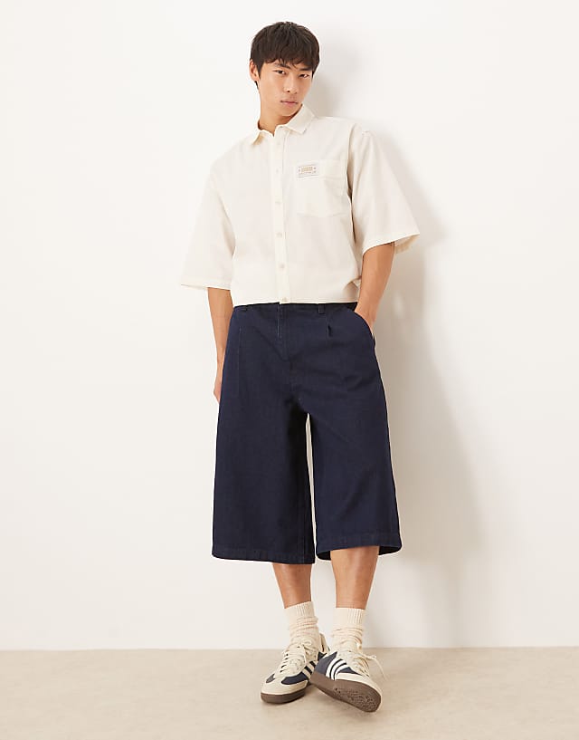 asos ASOS DESIGN longer length pleated denim jort in raw wash