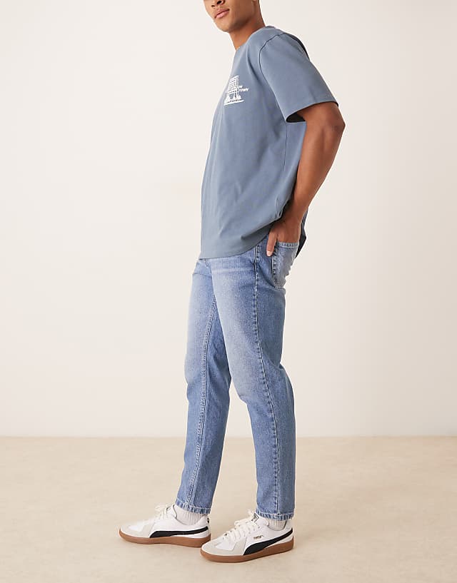 Asos ASOS DESIGN Tapered Fit Jeans In Light Wash Blue