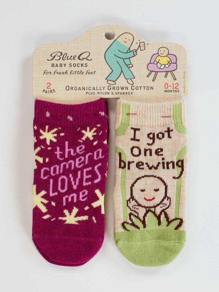 blue q The Camera Loves Me/ I Got One Brewing Baby Socks