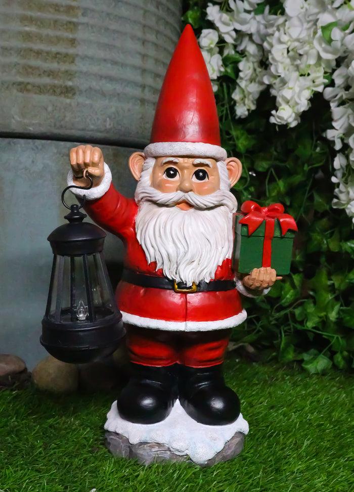 ebros gift Merry Christmas Santa Claus Holding Gift And Solar Colorful LED Lantern Statue