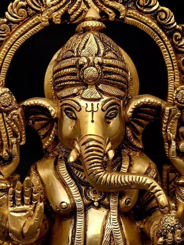 Exotic India 10" Four Armed Blessing Lord Ganesha Seated On Kirtimukha Throne | Brass Statue 