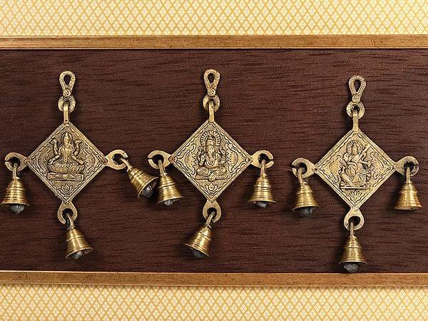 Exotic India 17" Lakshmi Ganesha And Saraswati With Bells In Brass | Wooden Wall Hanging Frame 