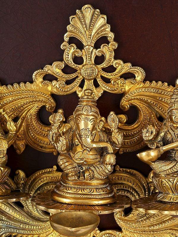 Exotic India 24" Lakshmi Ganesha Saraswati With Diya | Wood Framed Brass Sculpture | Wall Hanging 