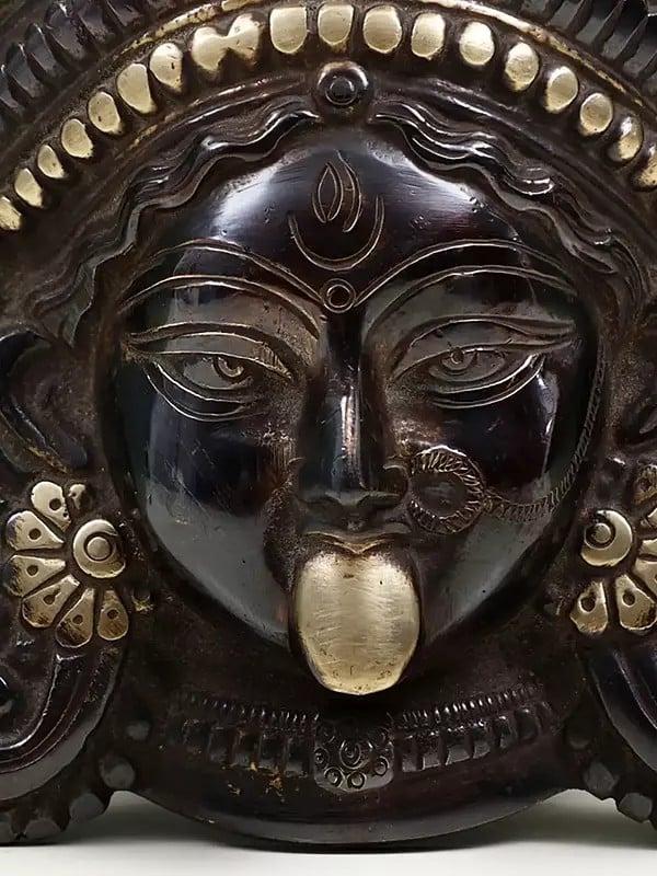 Exotic India 7" Serenity Of Kali Wall-Hanging Mask In Brass 