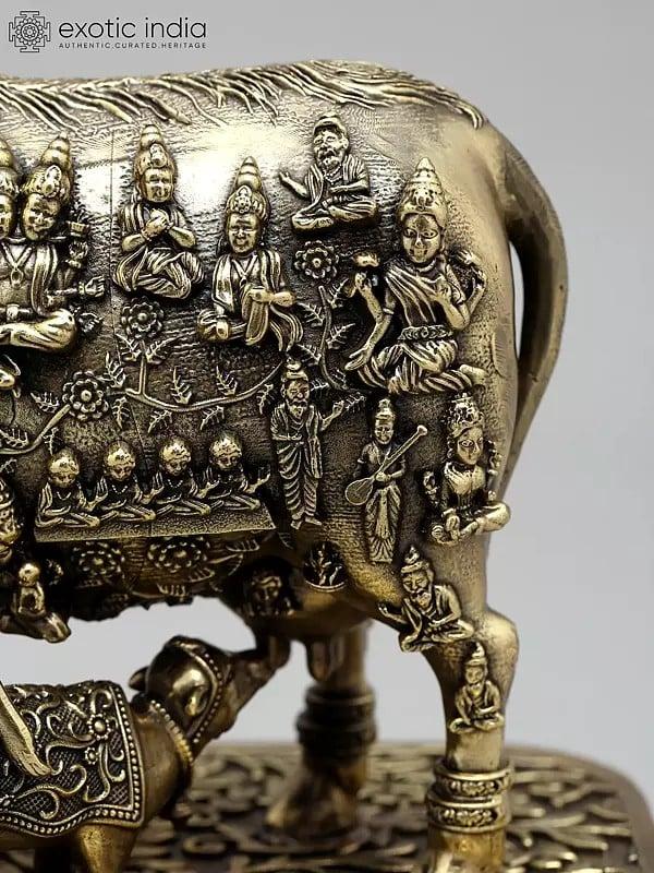 Exotic India 7" Superfine Kamadhenu Cow With All Gods And Goddesses | Brass Statue 