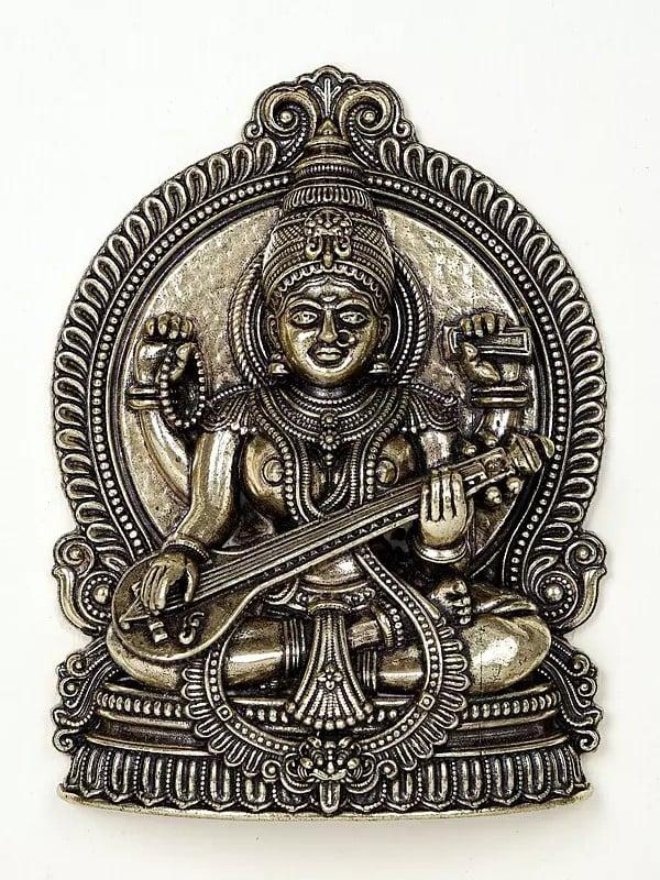 Exotic India 9" Superfine Sitting Goddess Saraswati | Wood Framed Brass Sculpture | Wall Hanging Decor 