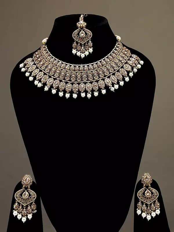exotic india Golden and White Stone Studded Necklace Set with Earrings and Mangtika 