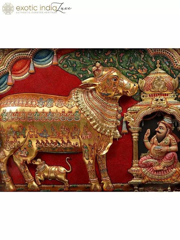 Exotic India Kamadhenu Cow With Vashist Muni Tanjore Painting With 22 Karat Gold Embossed Work | With Burma Teak Frame