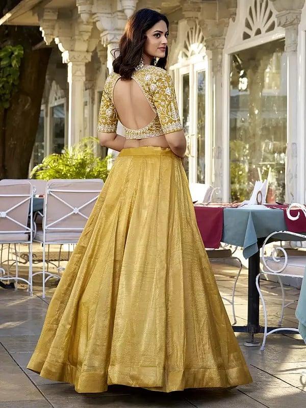 Exotic India Saffron-Mango Vichitra Silk Solid Attractive Lehenga Choli With Sequins And Embroidered Matching Dupatta 