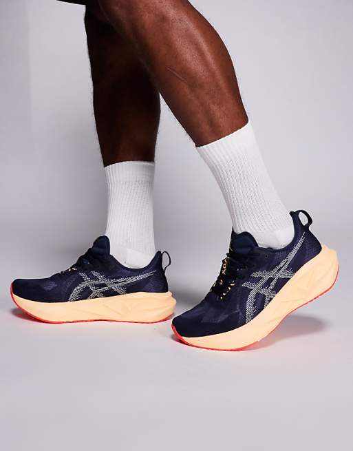 Asics Novablast 5 running trainers in midnight and orange glow