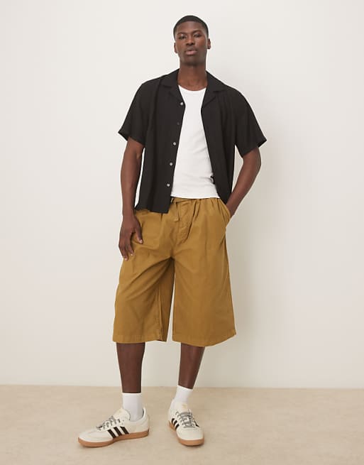 ASOS DESIGN longer length shorts with belt and pleats in olive green