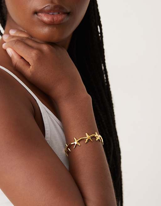 ASOS DESIGN stainless steel waterproof cuff bracelet with mini starfish detail in gold tone