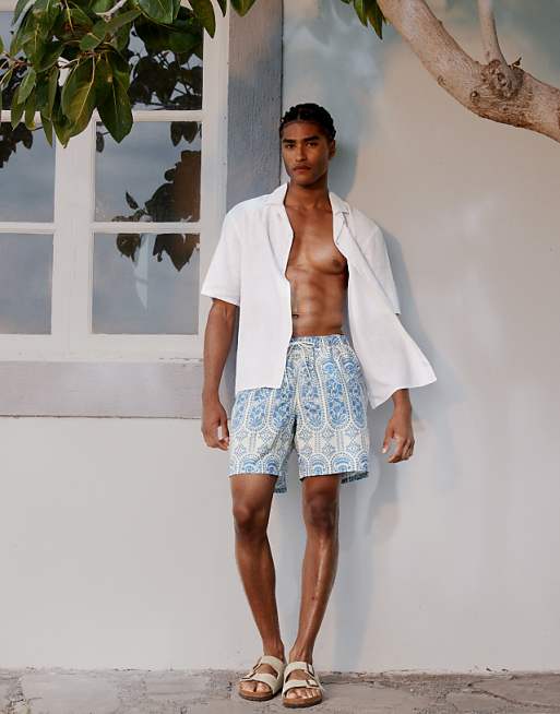 ASOS DESIGN swim short in mid length with ornate floral in blue