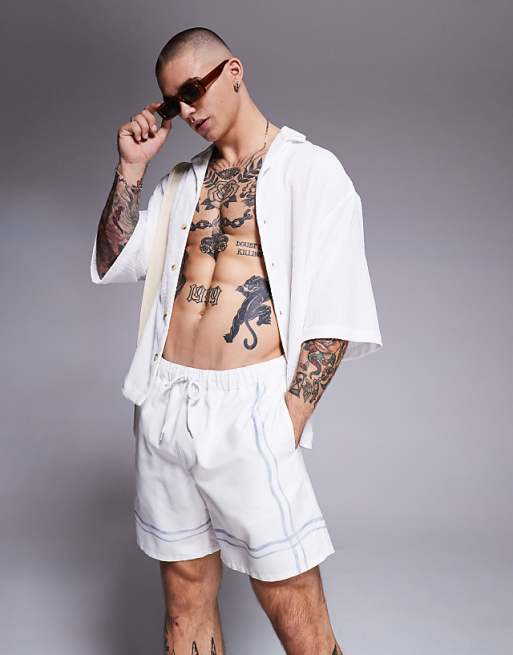 ASOS DESIGN swim shorts in mid length in stone with border print