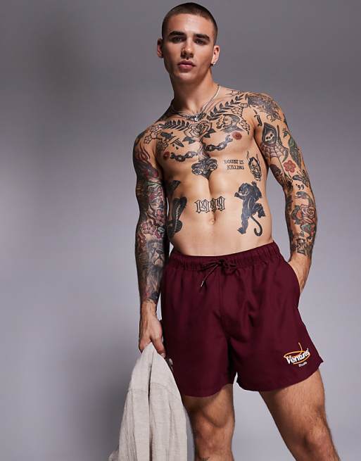 ASOS DESIGN swim shorts in short length with placement print in burgundy