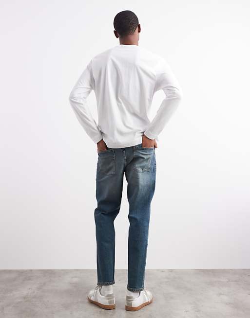 ASOS DESIGN Tapered Fit Jeans With Tint In Mid Wash Blue