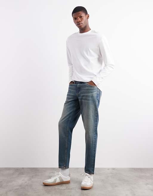 ASOS DESIGN tapered fit jeans with tint in mid wash blue