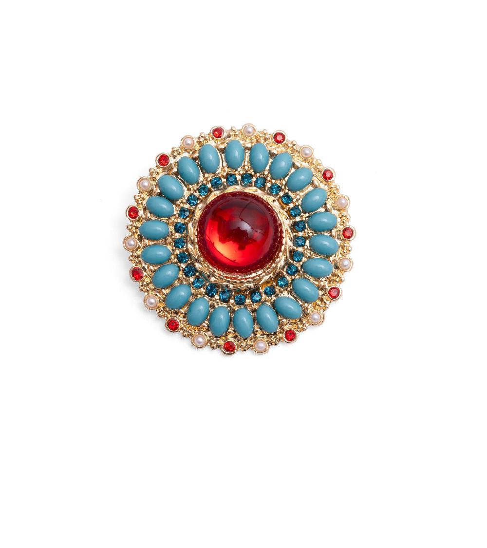 les basiles BROCHE GALA En perles bleues et blanches montées sur laiton plaqué or 18 carats et serti de cristaux rouges