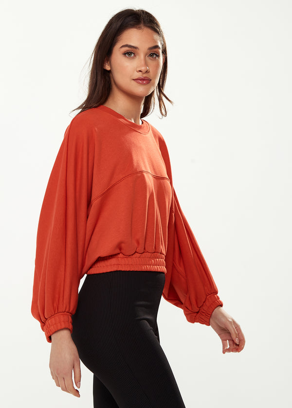 Liquorish Women's Cropped Sweatshirt In Dark Orange With Voluminous Bat And Balloon Sleeves Elastic Cuffs And A Chic Design