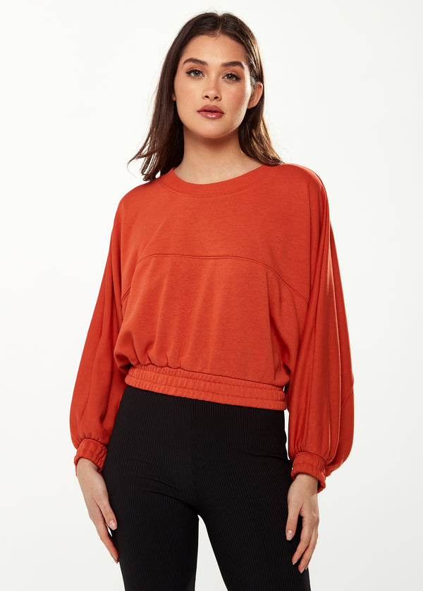 Liquorish Women's Cropped Sweatshirt in Dark Orange with Voluminous Bat and Balloon Sleeves Elastic Cuffs and a Chic Design