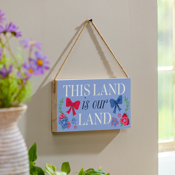 plow & hearth American Classic Red White & Bows Wood Hanging Sign w/ Rope "This Land Is Our Land" 11"x6"