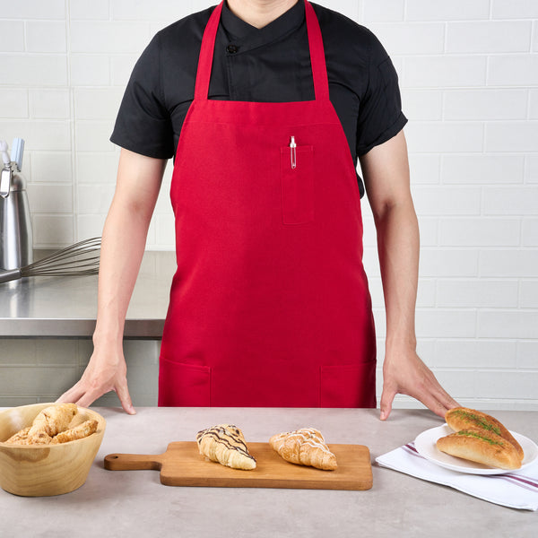 Restaurantware Chef 101 Red Standard Bib Apron - With 3 Pockets - 32 1/2'' X 27 1/2'' - 100 Count Box