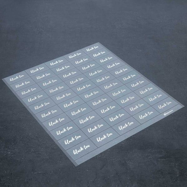 Restaurantware Label Tek Plastic Black Tea Label - Clear With White Font Water-Resistant - 2" X 1" - 100 Count Box