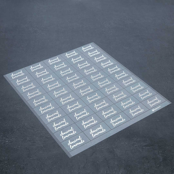 Restaurantware Label Tek Plastic Charcoal Lemonade - Clear With White Font Water-Resistant - 2" X 1" - 100 Count Box