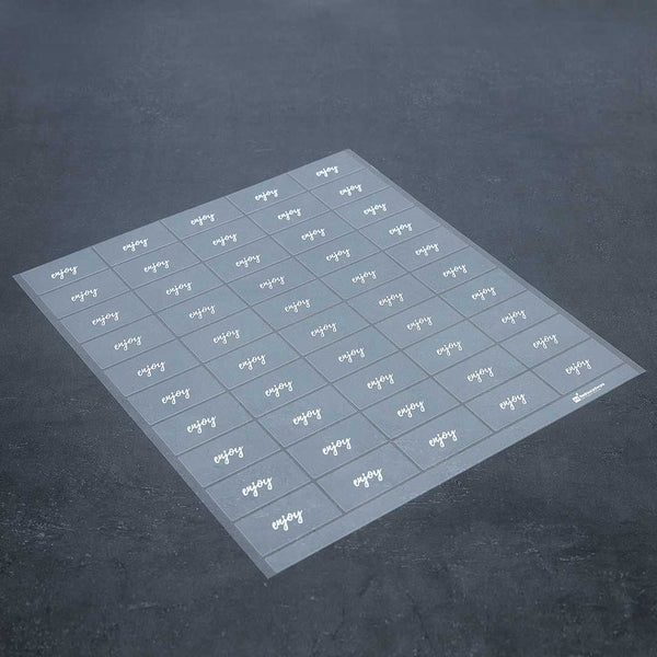 Restaurantware Label Tek Plastic Enjoy Label - Clear With White Font Water-Resistant - 2" X 1" - 100 Count Box