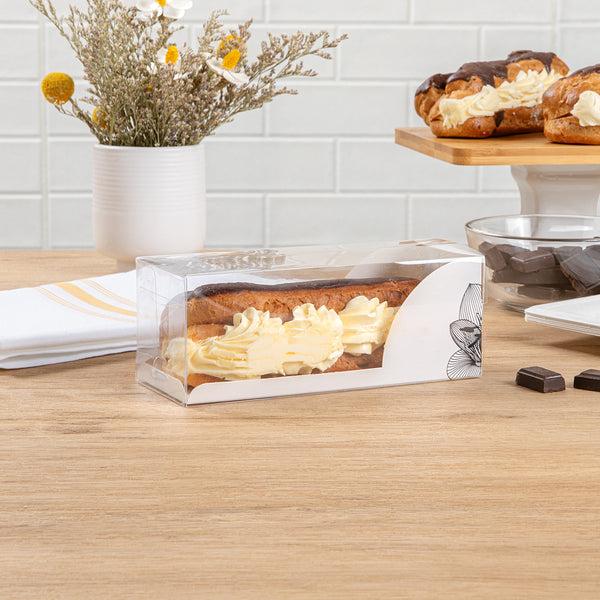 Restaurantware Sweet Vision Rectangle Clear Plastic Eclair Box - White Paper Sleeve Lotus Accent - 7" X 2 1/2" X 2 1/2" - 100 Count Box