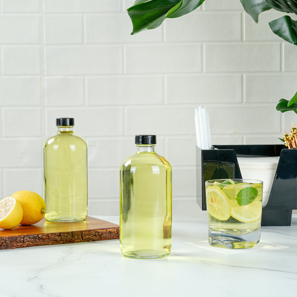 Restaurantware Vetri 16 Oz Boston Round Clear Glass Bottle - With Black Phenolic Cap - 3" X 3" X 6 3/4" - 12 Count Box