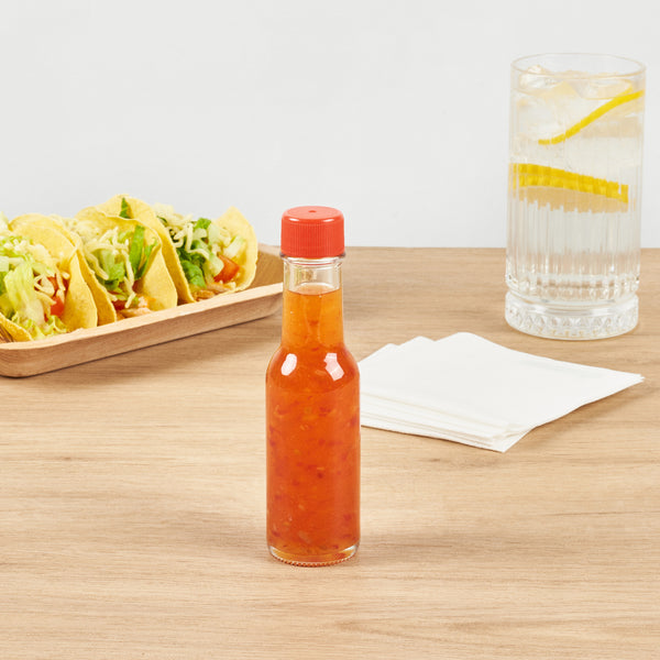 Restaurantware Vetri 3 Oz Glass Woozy Bottle - With Red Cap - 1 1/2" X 1 1/2" X 6" - 10 Count Box