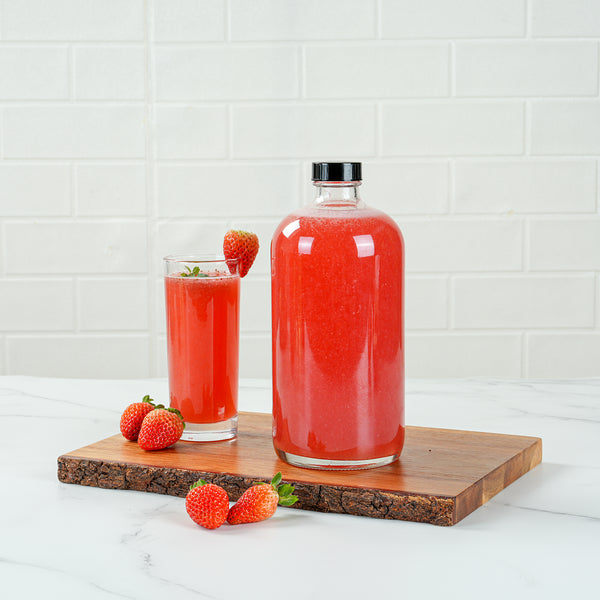 Restaurantware Vetri 32 Oz Boston Round Clear Glass Bottle - With Black Phenolic Cap - 3 3/4" X 3 3/4" X 8" - 12 Count Box