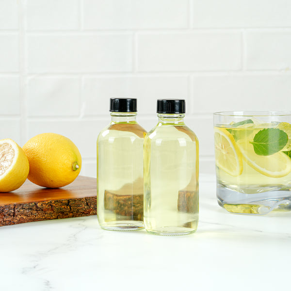 Restaurantware Vetri 4 Oz Boston Round Clear Glass Bottle - With Black Phenolic Cap - 2" X 2" X 4 1/2" - 24 Count Box