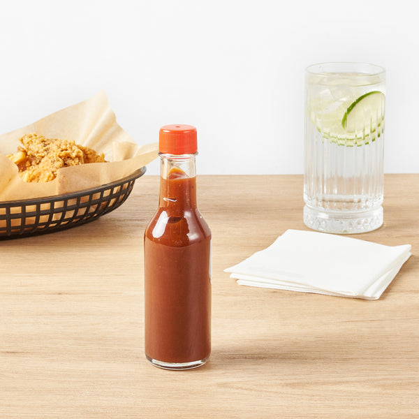 Restaurantware Vetri 5 Oz Glass Woozy Bottle - With Red Cap - 1 3/4" X 1 3/4" X 6 3/4" - 10 Count Box