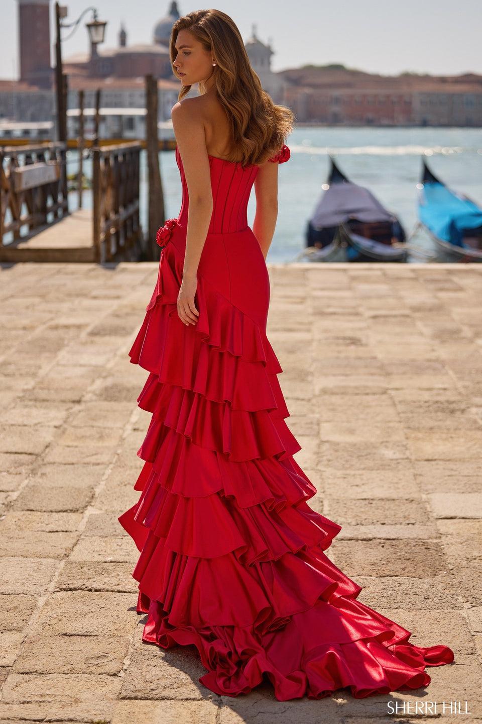 Sherri Hill One Shoulder Stretch Satin Gown With Corset Bodice Rosette Embellishments And A Ruffle Skirt With Slit