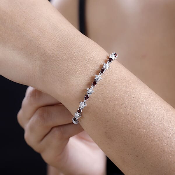 Shop Lc D'Joy Premium Anthill Garnet And Moissanite 5.30 Ctw Flower Bracelet In Rhodium Over Sterling Silver (7.25 In)